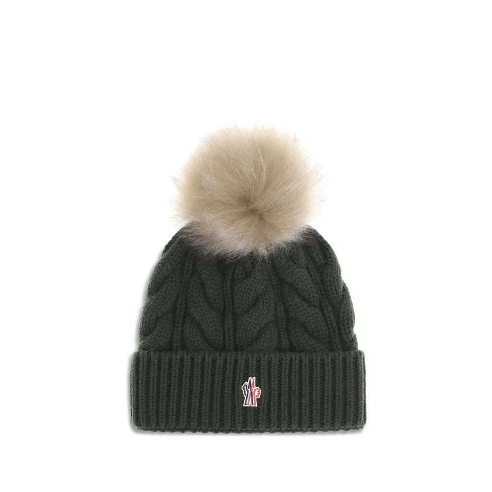 Dark green cable knit beanie with beige fur pom pom and small embroidered logo