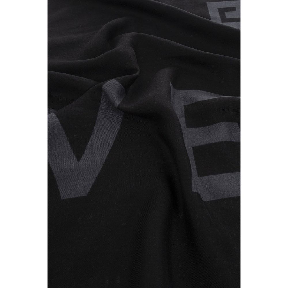 Close-up of black soft fabric with subtle large gray printed letters and wrinkles