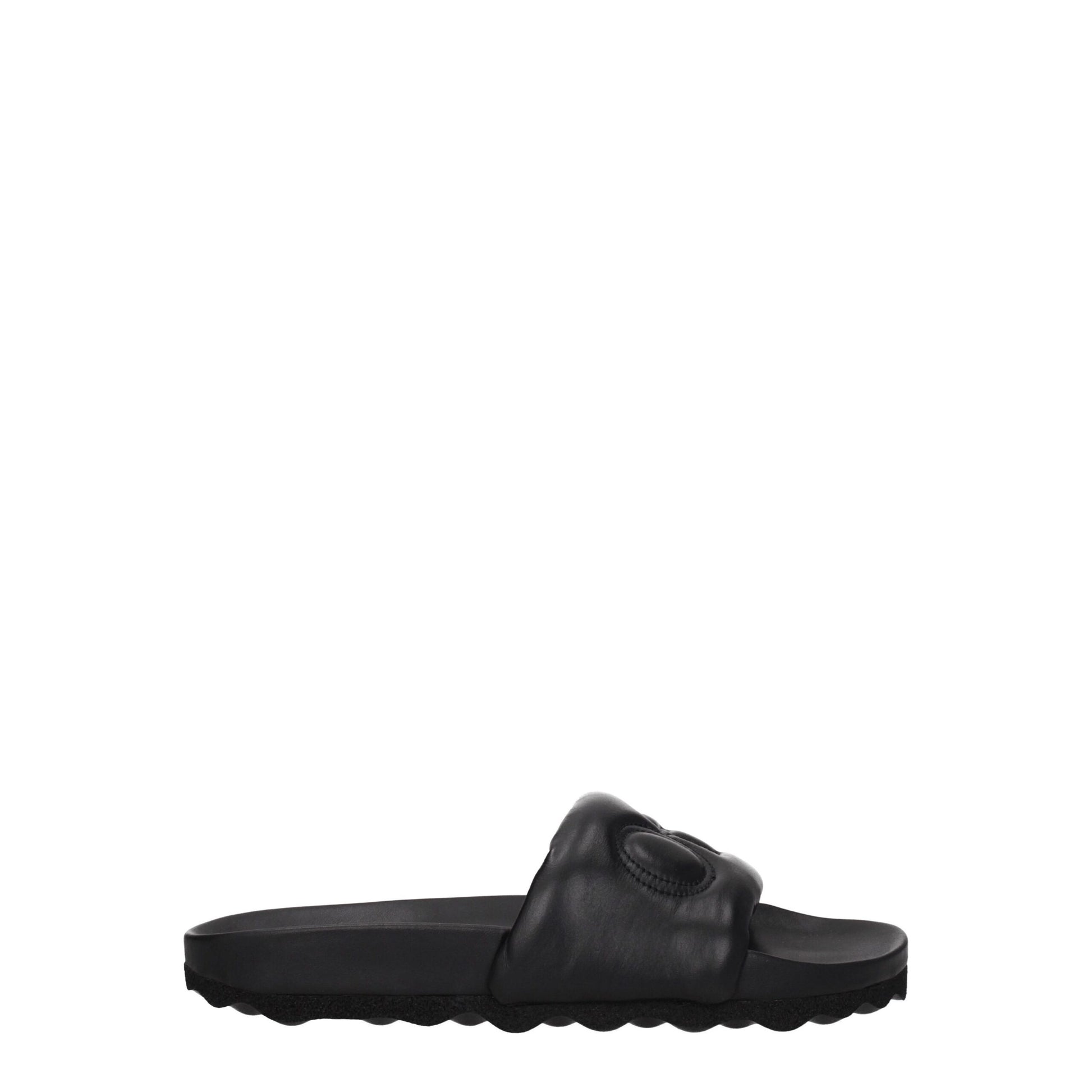 Black slide sandal with padded strap and textured sole on white background