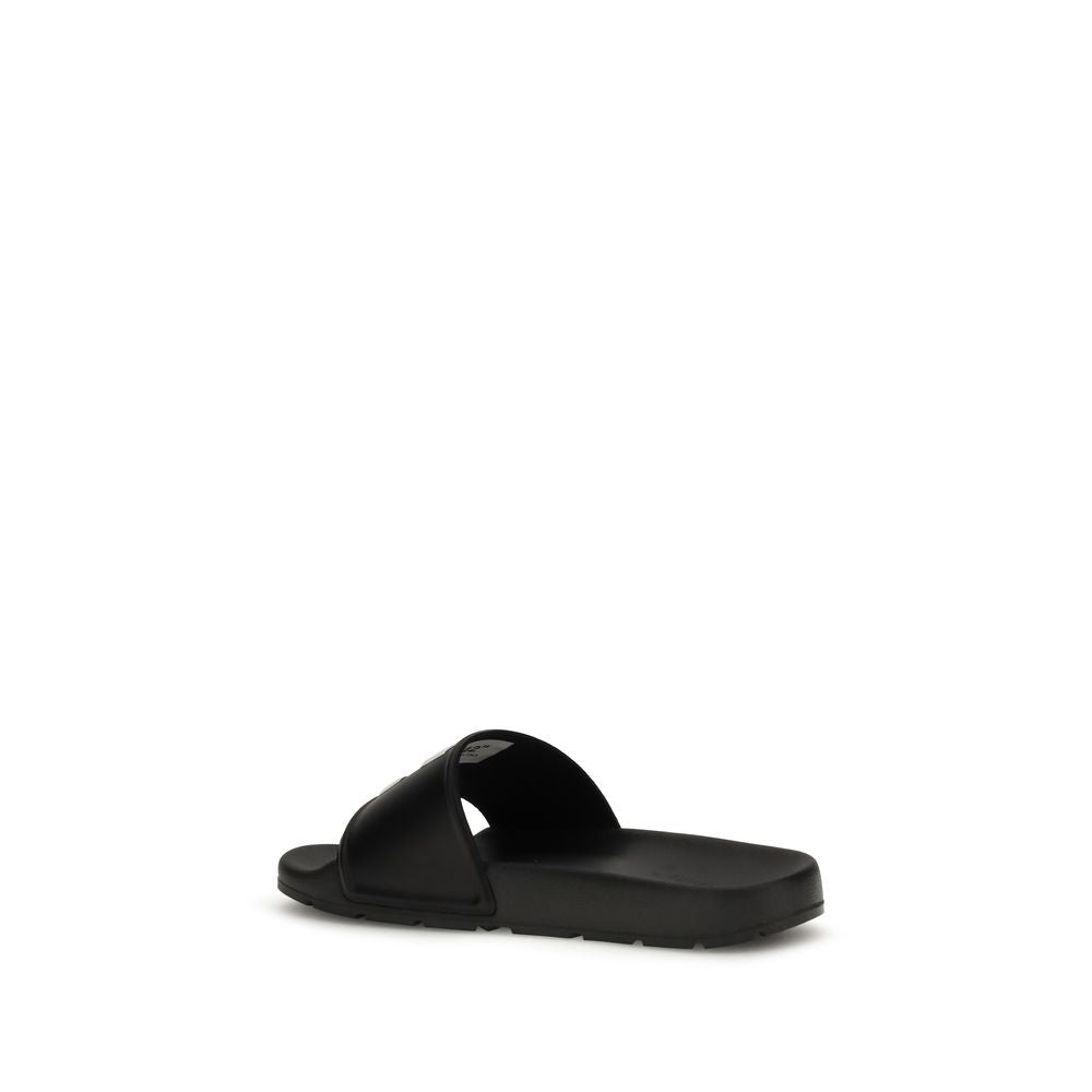 Black slide sandal with a wide strap and cushioned sole on white background