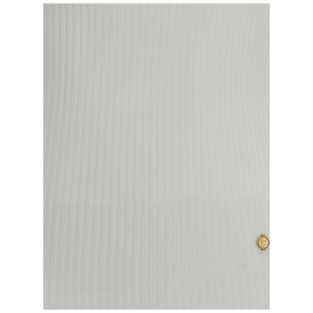 White ribbed fabric with a small gold decorative button or emblem