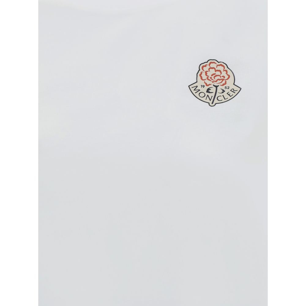 Close-up of white fabric with Moncler logo patch featuring red flower and text