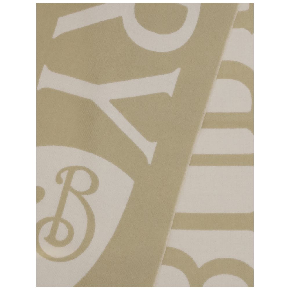 Close-up of beige and white fabric with large stylized letters and a decorative emblem pattern