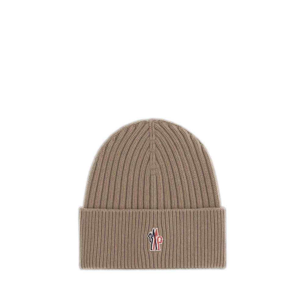 Beige ribbed knit beanie with a small embroidered tricolor logo on the cuff
