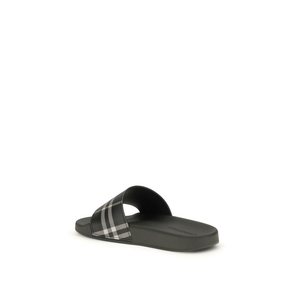 Black slide sandal with white plaid strap and flat sole on white background