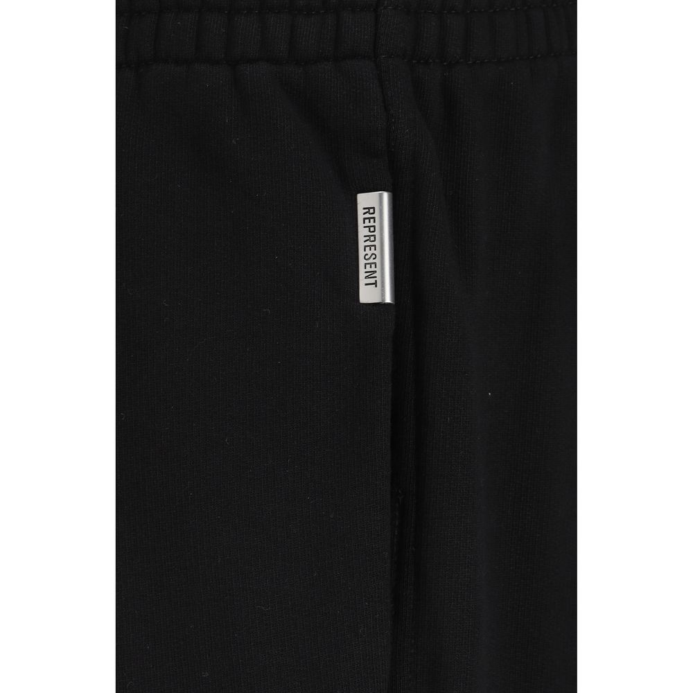 Close-up of black cotton sweatpants with a silver metal tag labeled REPRESENT near the elastic waistband