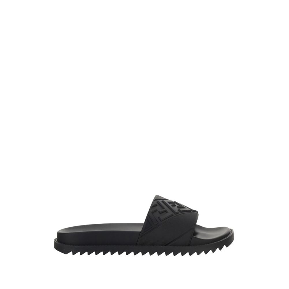 Black slide sandal with textured strap and jagged sole on white background