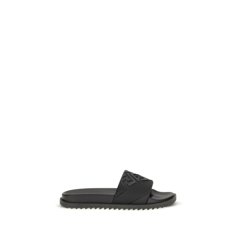 Black designer slide sandal with textured strap and serrated sole on white background