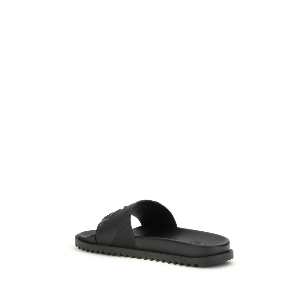 Black slide sandal with textured sole and wide strap on white background